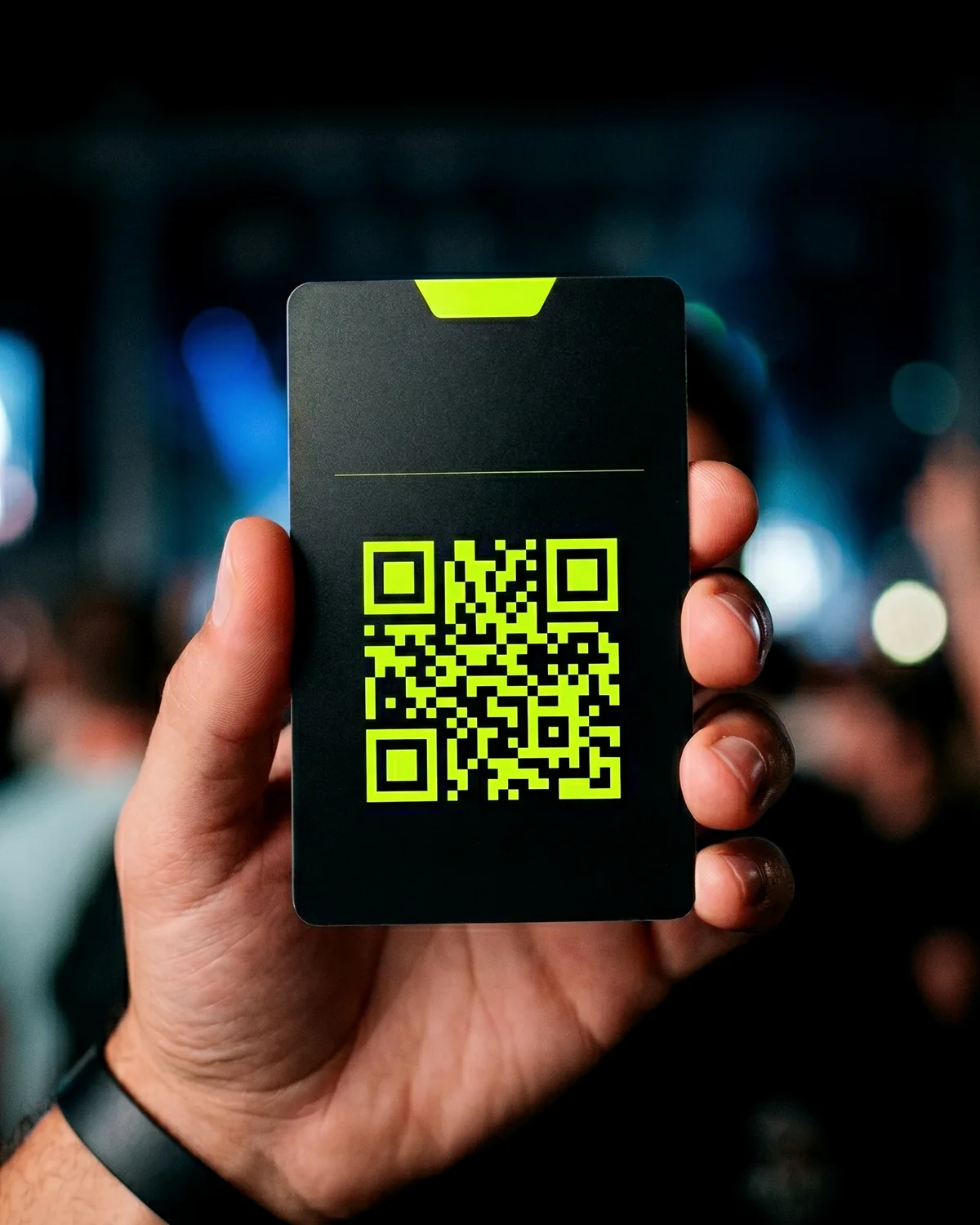 A fan holding a QR code access card at a night event